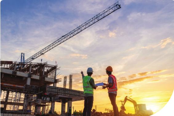 Civil engineers reviewing plans on an infrastructure site at sunset